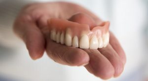 dentures in dentist's hand